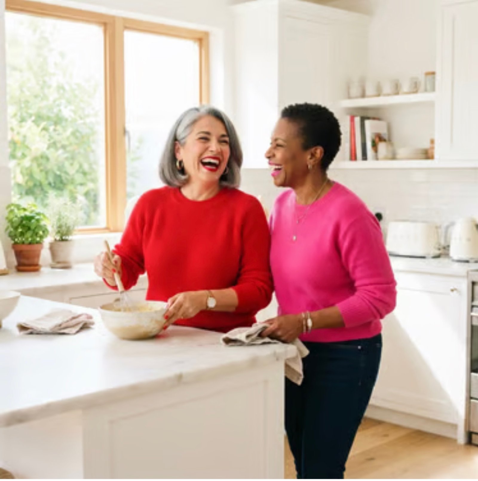 Two Esmeraldas laughing in a kitchen.